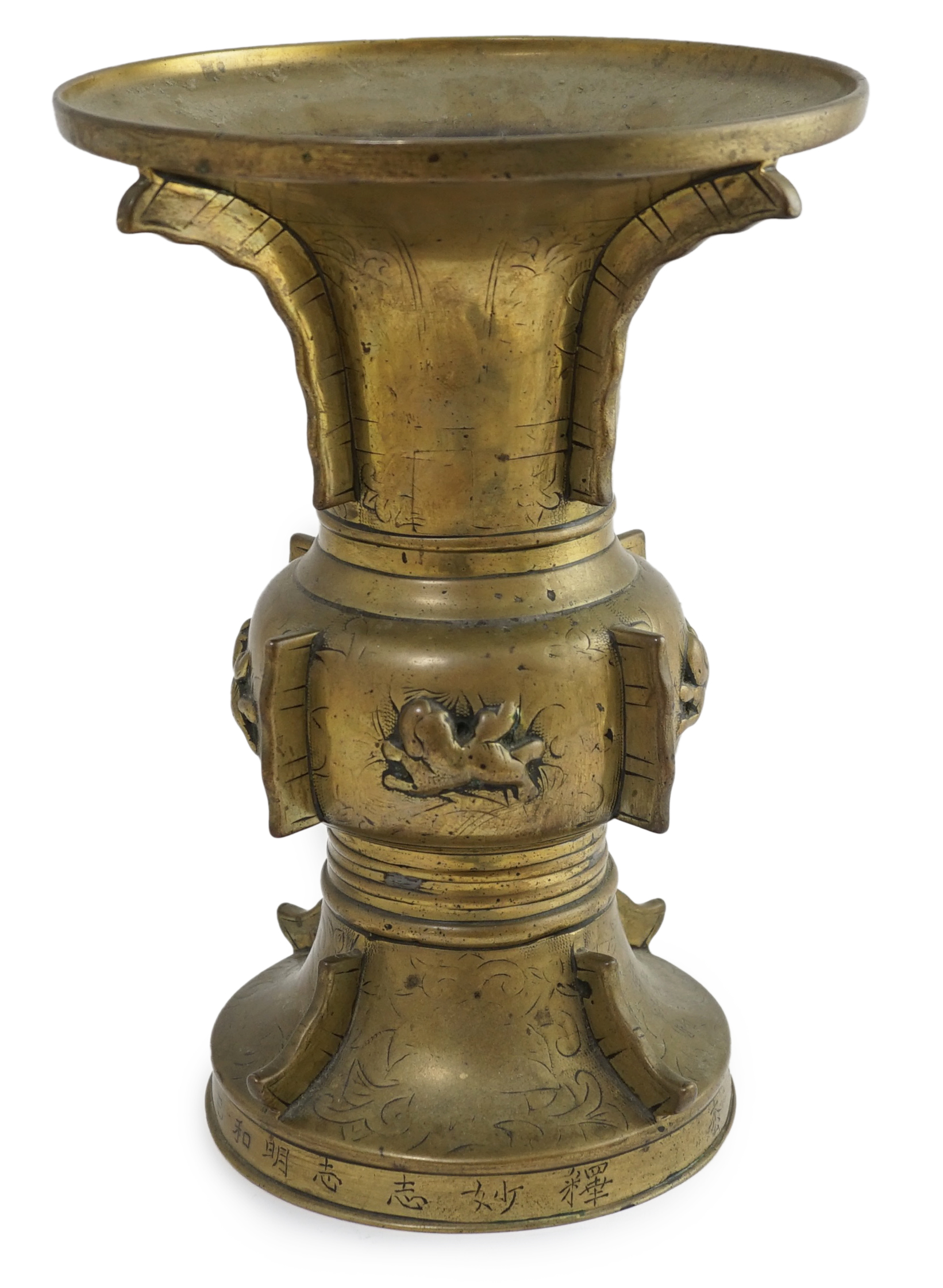 A Chinese inscribed archaistic bronze altar vase, gu, 19th century, the foliate engraved vase applied with raised fins and cast in relief with lion-dogs, the base engraved with an inscription, 33.7cm high. Condition - go